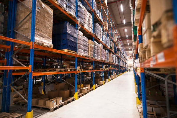A warehouse filled with shelfs and products, representing the logistics process.