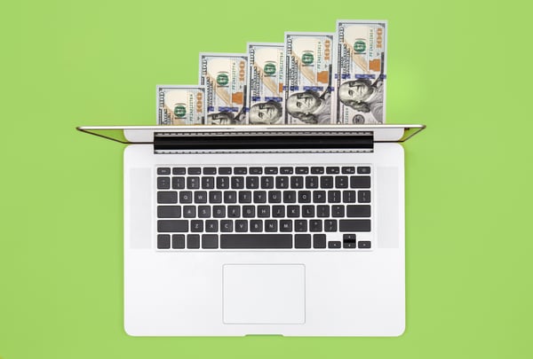 A green background with a white laptop and dollars, representing an online marketing budget.
