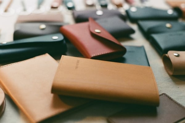 Photo shows several leather wallets on a table, in different colors, to illustrate article on the best dropshipping products to sell in 2023.