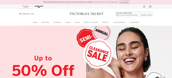 The main page of Victoria's Secret website, with the menu with different products categories from cosmetics to accessories, and the banner announcing clearance, with discounts in various products. The retailer's webpage is in tones of pink, white and black, with the Victoria's Secret logo on the top of the page.